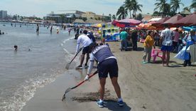Operarios limpian una playa contaminada en Veracruz.