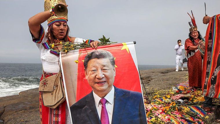 Una curandera sujeta un retrato del presidente de China, Xi Jinping, durante un ritual tradicional en Chorrillos, Lima.