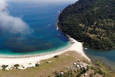 La costa del pueblo muestra arena clara y aguas que cambian de color según la luz.