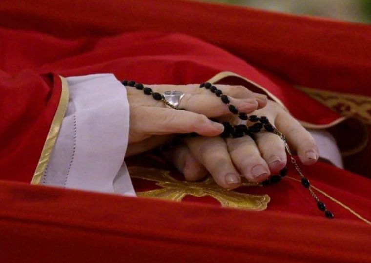 El papa Francisco en su féretro, con un rosario negro entre las manos Foto: X @VATICANNEWS