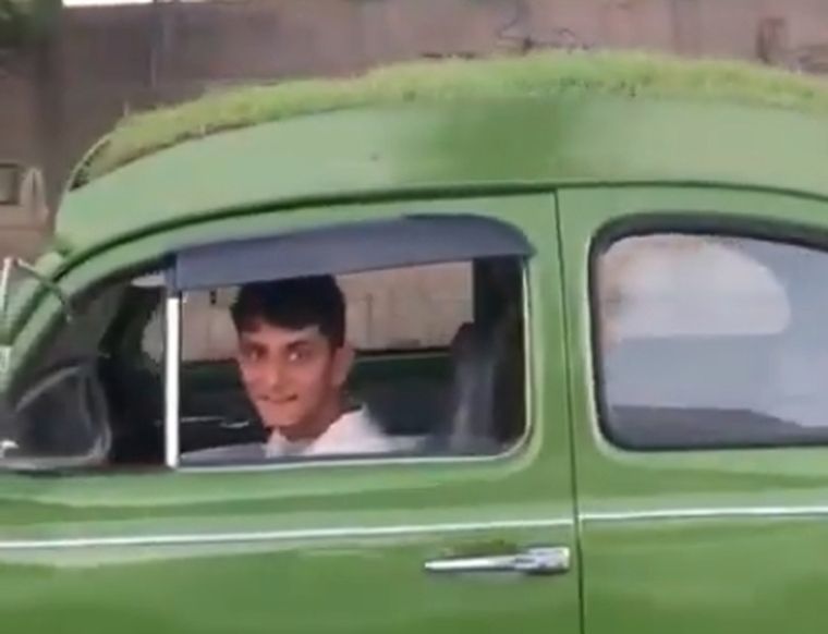 Natural El conductor, feliz sobre su escarabajo parquizado.