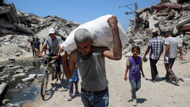 Un palestino lleva una bolsa con suministros de ayuda que entraron en Gaza, en Beit Lahia, en el norte de Gaza.