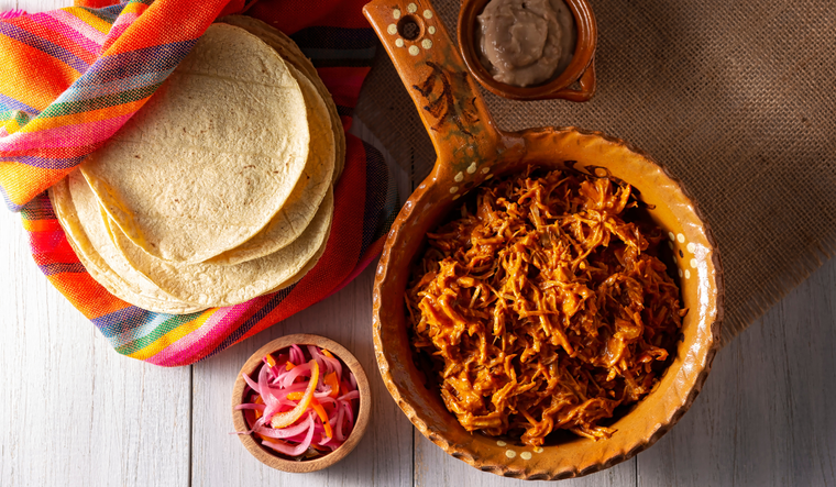 La receta tradicional no llevaba naranja agria, sino jugo de lima local, pero con el tiempo se adaptó a ingredientes más accesibles.