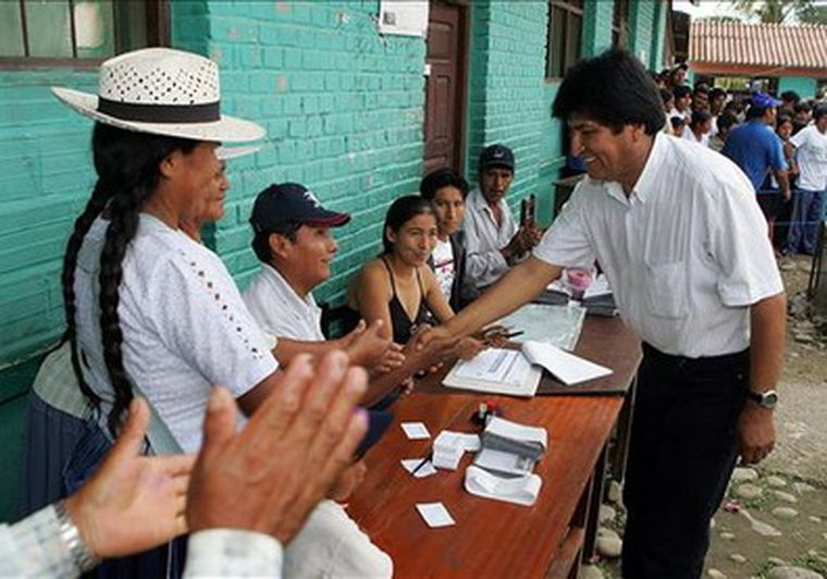 Evo Morales saluda a los jurados de una de las mesas electorales establecidas en Cochabamba. Foto: EFE