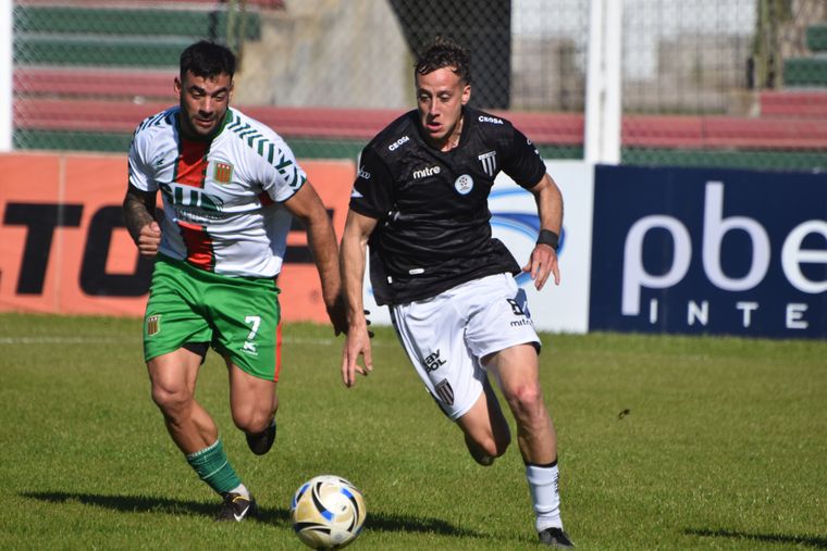 Matías Muñoz, defensor de Gimnasia, intenta salir jugando ante la presencia del delantero Brian Blando, autor del segundo gol de Agropecuario.