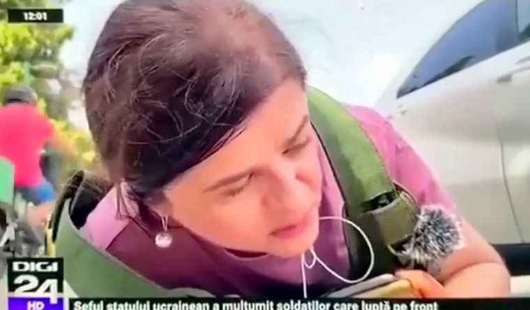 La periodista en el piso y un ciclista a su lado. Foto: Captura de pantalla.