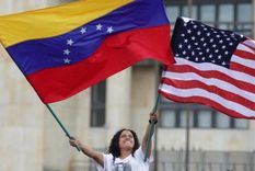 Una mujer ondea las banderas de EE.UU. y Venezuela.