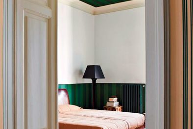 MDZol | En la imagen el método sándwich representado en una habitación con un verde fuerte y estampado en las partes superior (techo) e inferior (empapelado) con un contraste brillante y claro en la pared, cama y puerta. Foto: Farrow & Ball