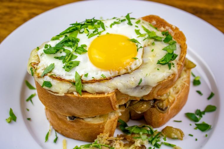 El huevo que corona la receta de croque madame simboliza un sombrero femenino, de ahí su nombre. El huevo que corona la receta de croque madame simboliza un sombrero femenino, de ahí su nombre.