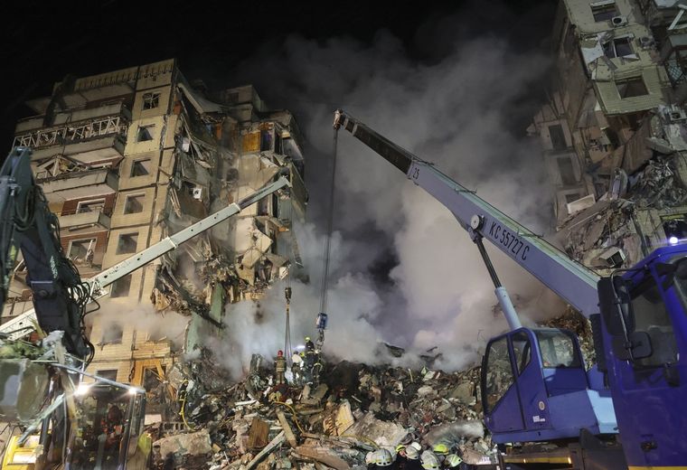 Los equipos de rescate buscan esta madrugada a 26 personas entre los escombros del edificio residencial de Dnipró que fue derrumbado este sábado por el impacto de un misil ruso, que ha causado la muerte a 12 personas y se elevan a 73 las heridas, entre ellas 14 niños, según medios locales. Foto: EFE/ Sergey Kozlov