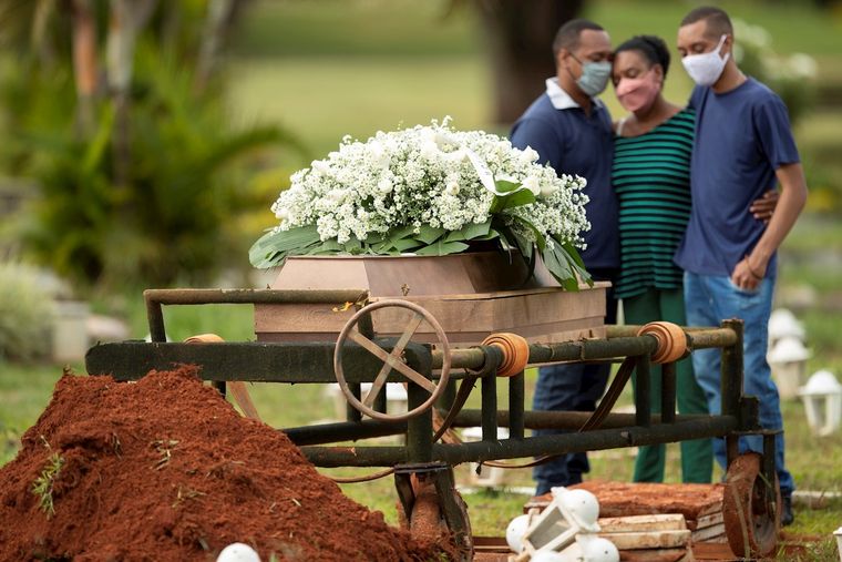 Un grupo de personas despide a un ser querido víctima de coronavirus en el cementerio Campo da Esperança, en Brasilia Foto: EFE
