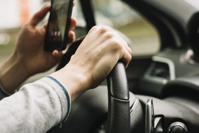 MDZol | Hombre conduciendo un auto con el celular en la mano