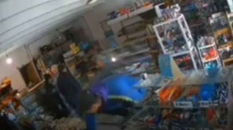 Uno de los autores del asalto traspasando el mostrador para sustraer mercadería y dinero de la recaudación.&nbsp;