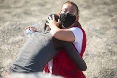 En esta foto, del 18 de mayo, capturada por Marcos Moreno, se ve a Luna Reyes, voluntaria de la Cruz Roja, brindándole ayuda al inmigrante que acababa de salir del mar. Foto: MARCOS MORENO/ANADOLU AGENCY VIA GETTY IMAGES