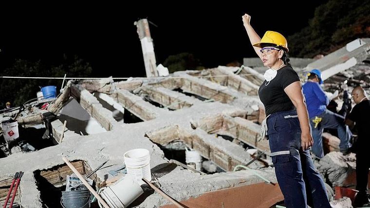 Una rescatista pide silencio para escuchar posibles voces de sobrevivientes durante operaciones de rescate en Cali tras el terremoto del 10 de agosto en el occidente de Colombia.