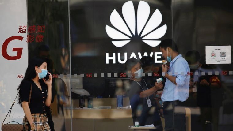 Un empleado mide la temperatura corporal de un hombre dentro de una tienda Huawei en un centro comercial. Foto: RT