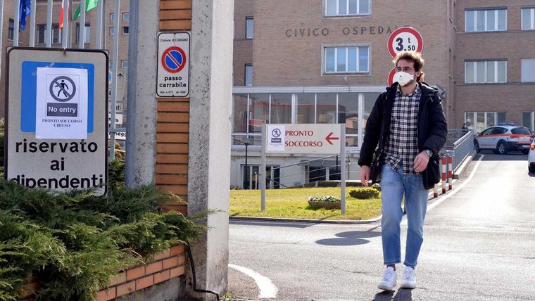 Un italiano camina con barbijo en las afueras de un hospital