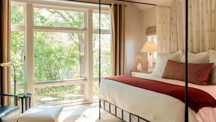 En este dormitorio los tonos beige y neutros se realzan con textiles rojos. Foto: Blackberry Farm Design