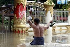 Un hombre carga comida mientras avanza entre las inundaciones en Myanmar. Foto: Efe.
