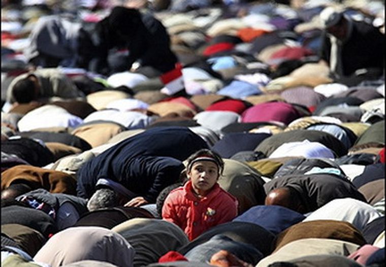 Un niño observa a la cámara en medio de una multitudinaria oración.