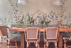 En esta imagen lo natural está incorporado con muebles que combinan madera y ratán, y arte floral en el empapelado. Foto: Sarah Griggs