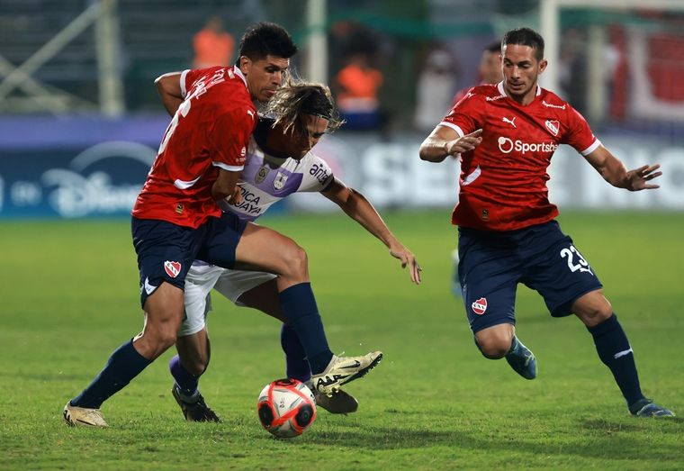 Sebastián Valdez, el único refuerzo del Rojo que fue titular, intenta frenar a Spinelli mientras Iván Marcone llega para ayudar. Foto: FotoBaires