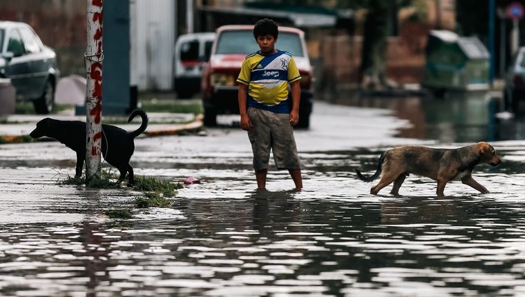 Un niño con el agua por encima del tobillo en La Plata luego del temporal. Foto: EFE