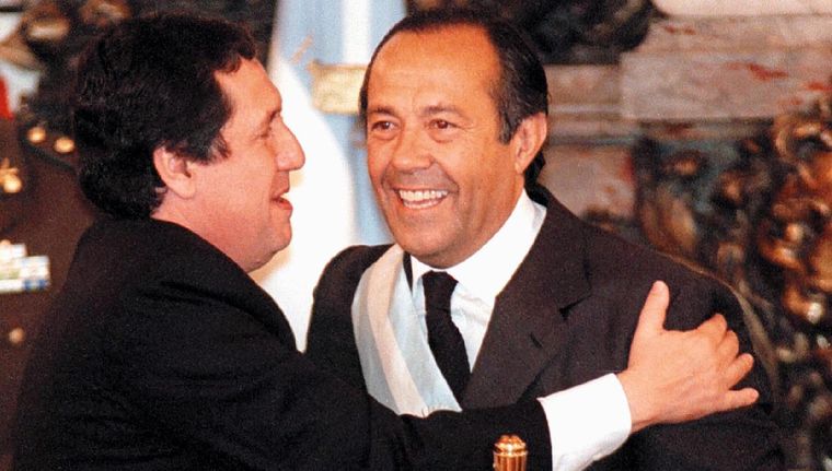 Rodríguez Saá recibe los atributos de mano de Ramón Puerta. Foto: NA