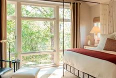 En este dormitorio los tonos beige y neutros se realzan con textiles rojos. Foto: Blackberry Farm Design