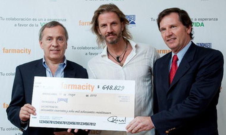Guillermo Bustos, Facundo Arana y Gustavo Anselmi muestran orgullosos el cheque simbólico con el monto recaudado. Foto: Gentileza