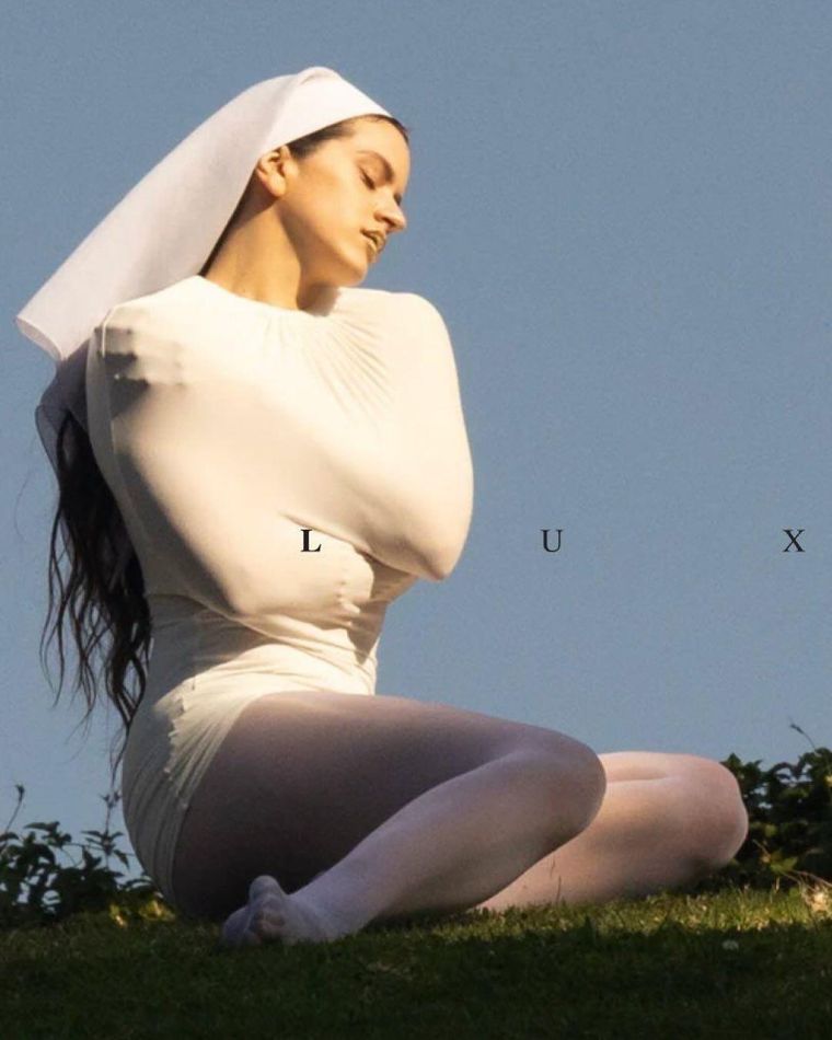 La carátula del álbum muestra a Rosalía abrazándose mientras porta un velo de monja, reflejando temas de autoaceptación y búsqueda espiritual. La carátula del álbum muestra a Rosalía abrazándose mientras porta un velo de monja, reflejando temas de autoaceptación y búsqueda espiritual.