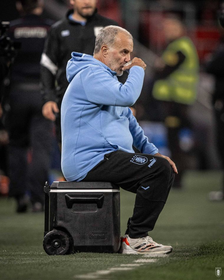 Sentado en la hielera, la característica imagen de Bielsa mirando el partido. Foto: @AUF
