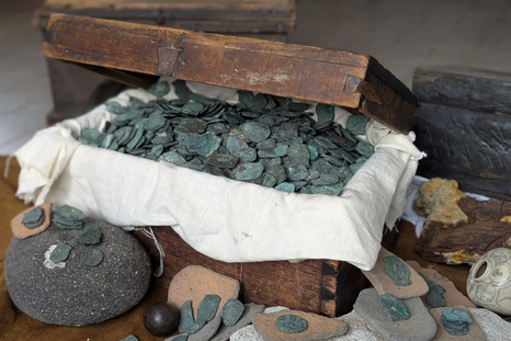 Cofre repleto de monedas y restos arqueológicos hallados en el área conocida como la “Costa del Tesoro” de Florida, vinculados a los naufragios de la flota española de 1715.