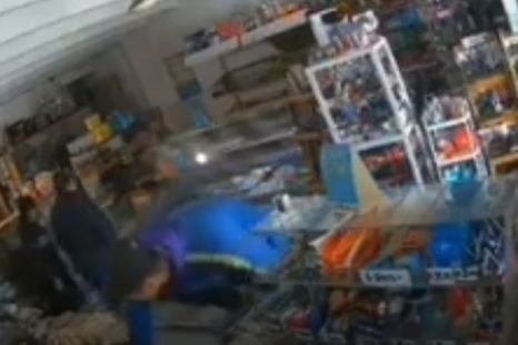 Uno de los autores del asalto traspasando el mostrador para sustraer mercadería y dinero de la recaudación. Uno de los autores del asalto traspasando el mostrador para sustraer mercadería y dinero de la recaudación.