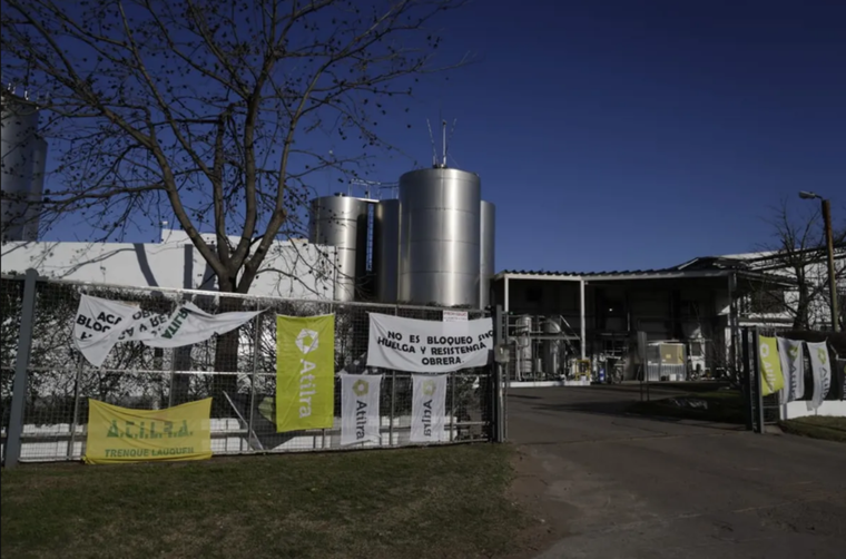 La entrada a Lácteos Vidal con banderas de Atilra, el gremio lechero que paralizó a la planta.