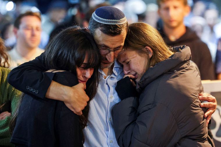 Las hermanas y el padre del soldado israelí fallecido Daniel Shimon Peres se abrazan durante su funeral. El de Peres ha sido uno de los cuerpos entregados por Hamás esta semana.