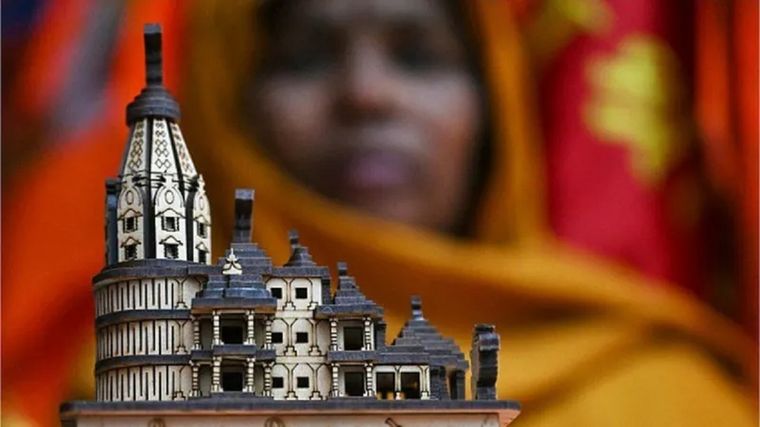 Una comerciante muestra una maqueta del nuevo templo de Rama antes de la ceremonia de inauguración en Ayodhya. Foto: AFP
