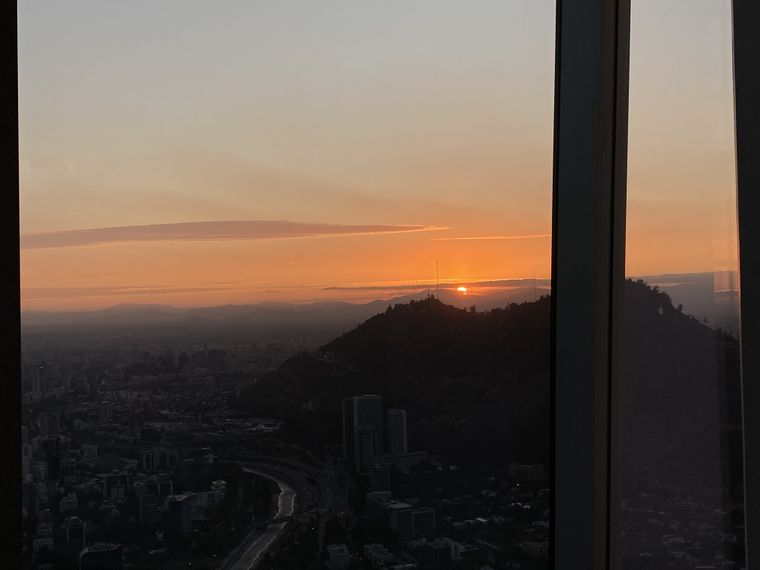 Atardecer sobre Santiago visto desde el Sky Costanera, con el sol escondiéndose detrás de los cerros que rodean la ciudad. Atardecer sobre Santiago visto desde el Sky Costanera, con el sol escondiéndose detrás de los cerros que rodean la ciudad.