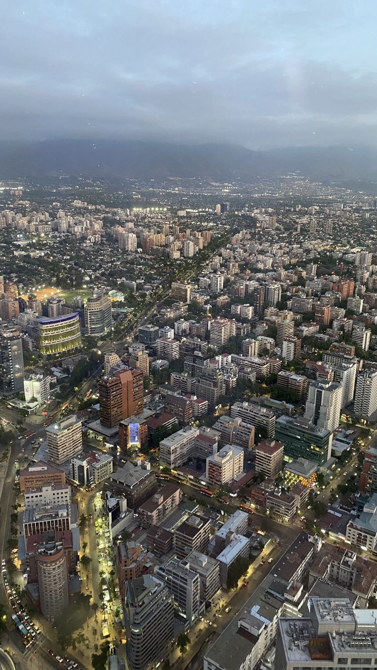 Vista de Santiago desde casi 300 metros de altura: avenidas, edificios y barrios que se extienden hasta la cordillera. Vista de Santiago desde casi 300 metros de altura: avenidas, edificios y barrios que se extienden hasta la cordillera.