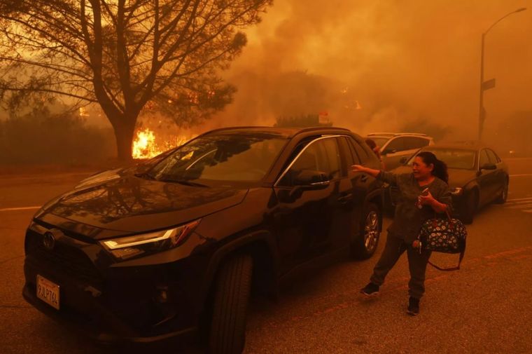 Miles de personas evacúan voluntariamente sus casas ante el avance del fuego en Los Ángeles Foto: EFE
