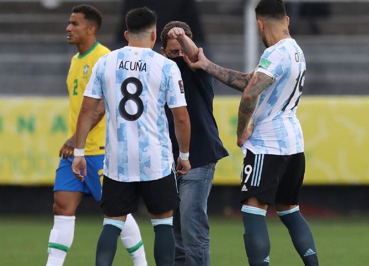 Acuña y Otamendi intentan sacar al intruso del campo. Foto: Fox Sports