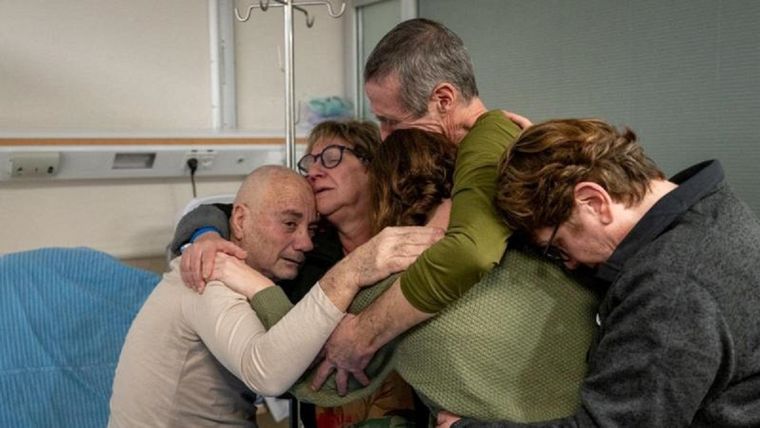 Luis Norberto Har (izquierda) y Fernando Marman (con camiseta verde y cabello gris) abrazan a varios familiares tras su rescate. Foto: Reuters