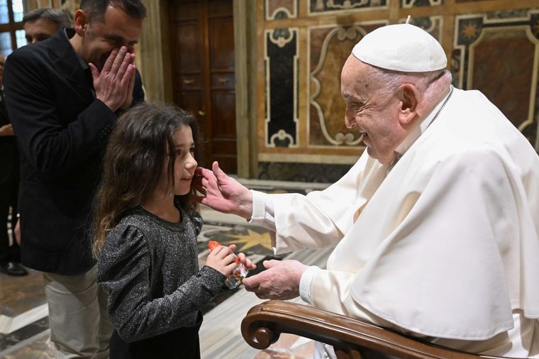 El Papa recibe a una niña que lo mira fijamente. Foto: EFE