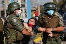Una mujer es detenida después de gritar consignas contra la policía antidisturbios en un barrio pobre de la comuna El Bosque, en Santiago, Chile.