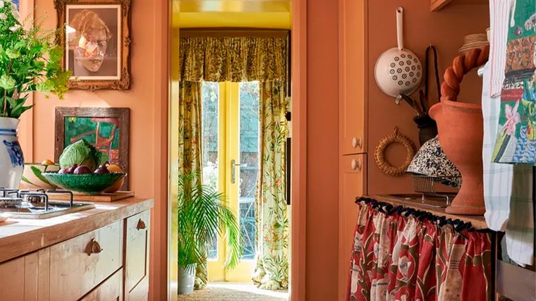 Este naranja impregna en todas las paredes de esta cocina un cálido telón de fondo para resaltar su colorida cerámica.