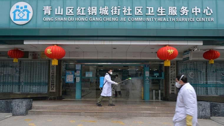 Un médico desinfecta la entrada de un centro de servicios de salud comunitario en el distrito Qingshan de Wuhan, China, el 2 de febrero de 2020.