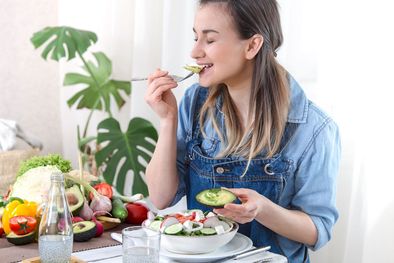 MDZol | young-and-happy-woman-eating-salad-at-the-table.jpg mujer comiendo ensaladas