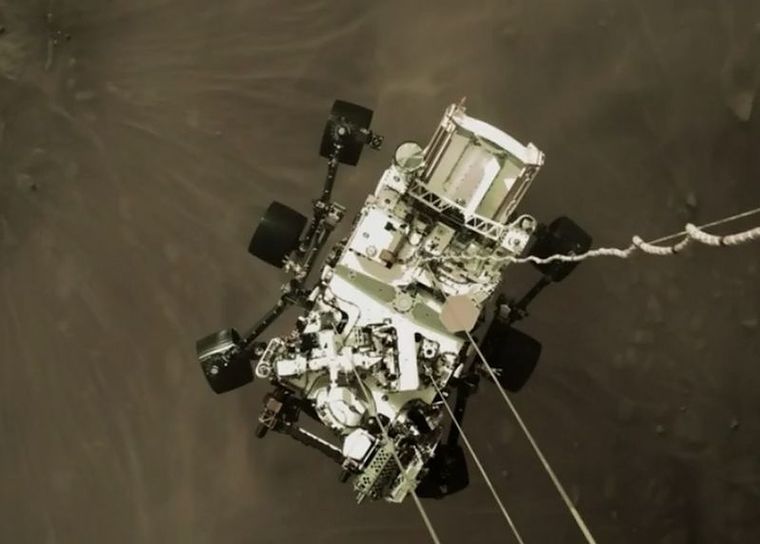 El robot Perseverance cuando estaba aterrizando en Marte, visto desde el cohete que ayudó en su descenso. Foto: NASA