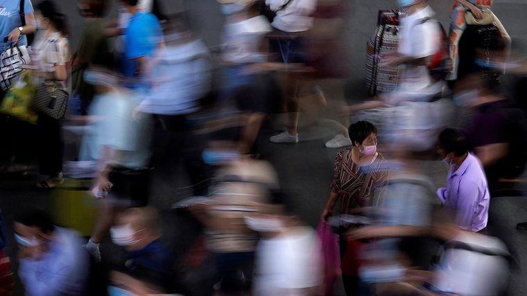 Personas con mascarillas faciales esperan el tren en la estación en Suzhou, China