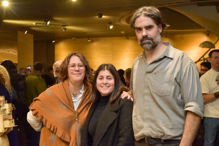 Los artistas Laura Rudman y Fernando Rosas posan junto a la chef Julieta Argento en la inauguración de la muestra.